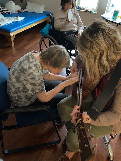 Woman with disabilities playing the guitar